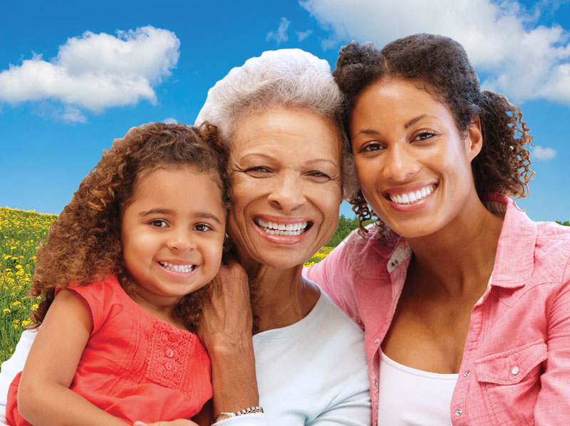 Two woman with a young child smiling.