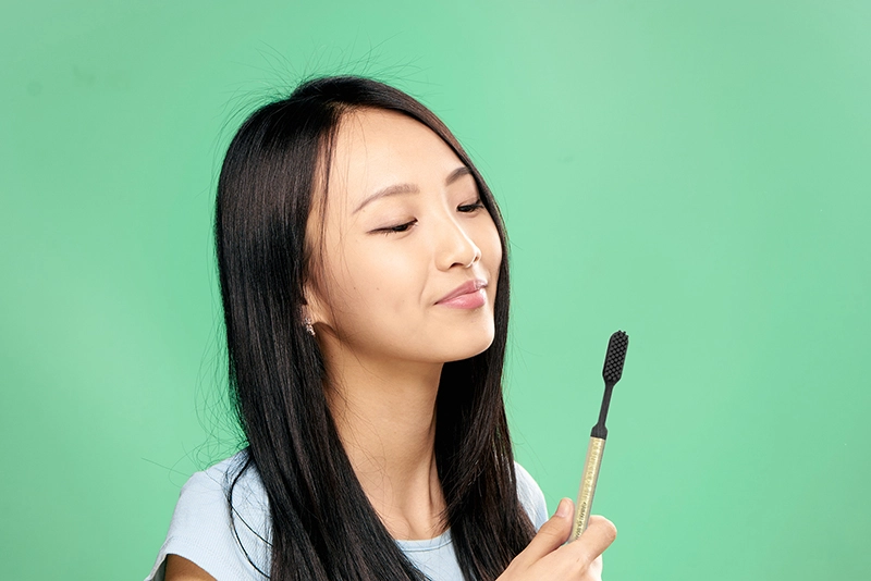 Woman with gold toothbrush